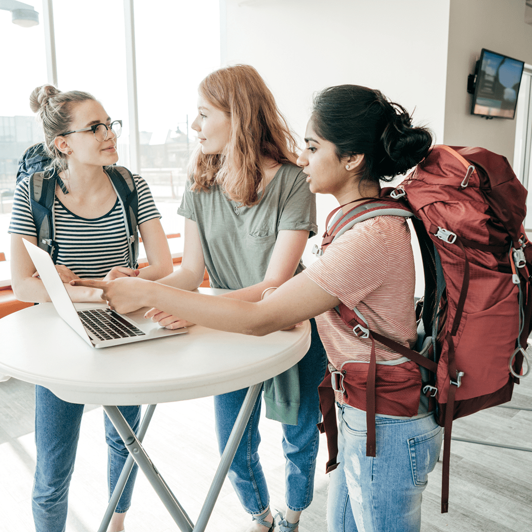 Students with backpacks discussing a project